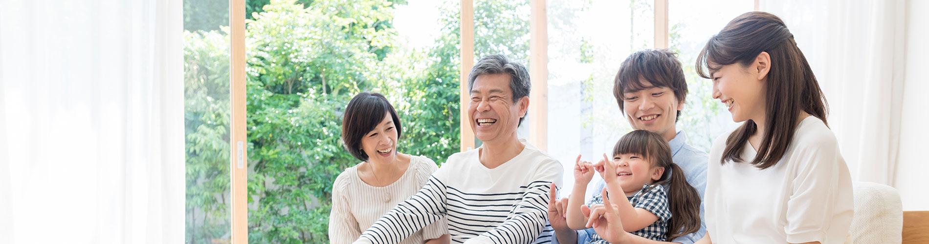 縁側で笑顔で語らう三世代の家族