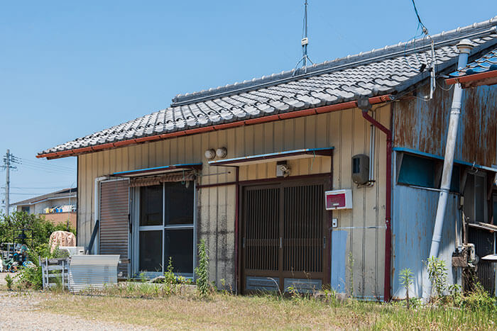雑草が伸び、人が住まなくなった相続空き家の戸建て